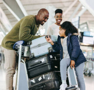 Father and mother waiting with young daughter at airport. Tourist family at airport terminal with luggage holiday.