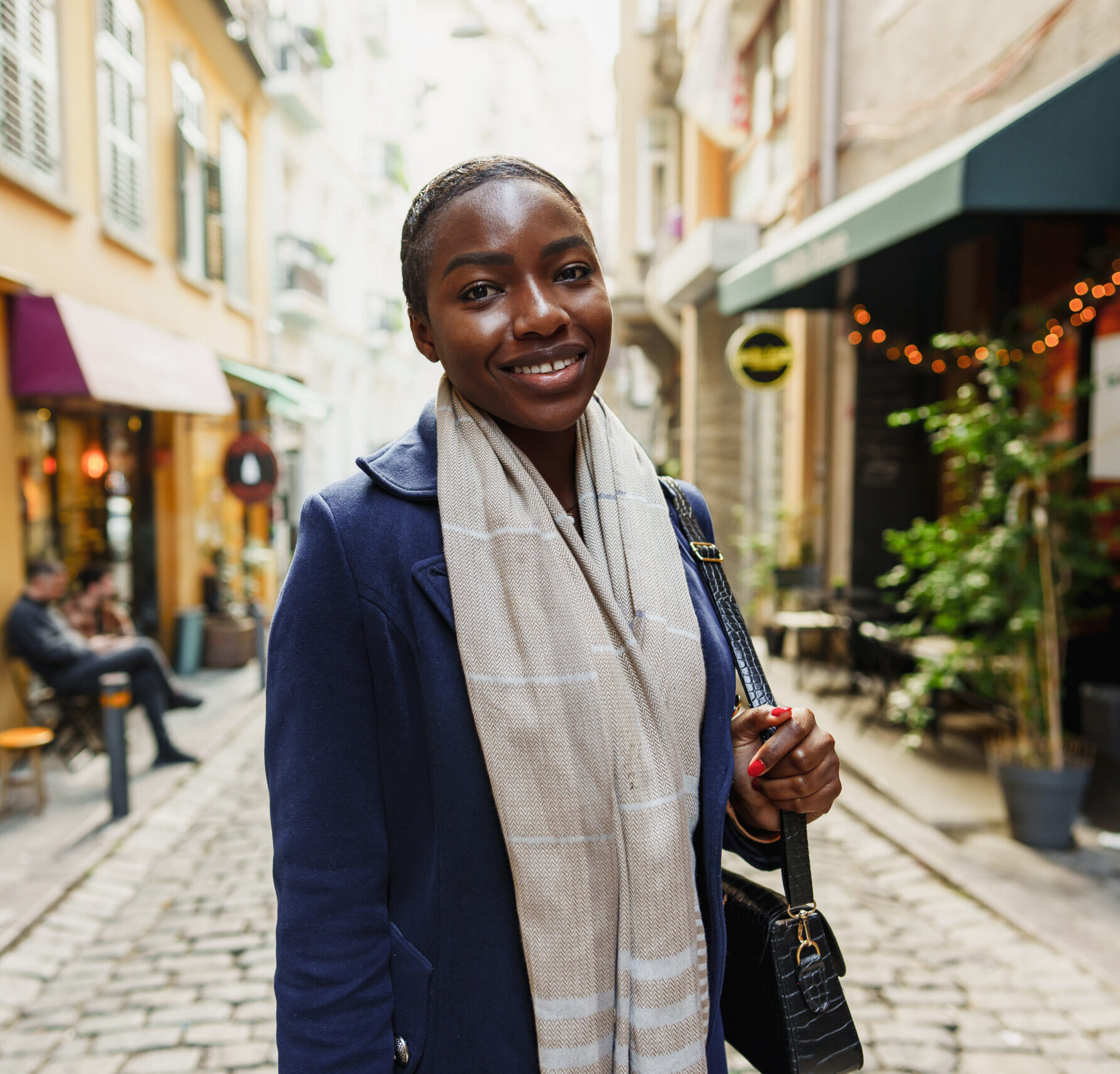 Young african woman walks alone on europe street close up